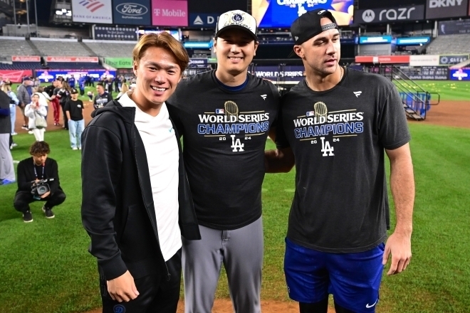 シャンパンファイト後、大谷（中央）＆フラハティ（右）と記念撮影に収まる山本（左）。(C)Getty Images