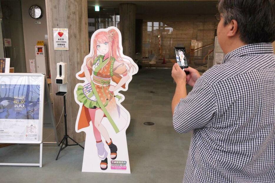 アイドルマスターのフォトパネルを撮影するファンの男性=筑西市丙