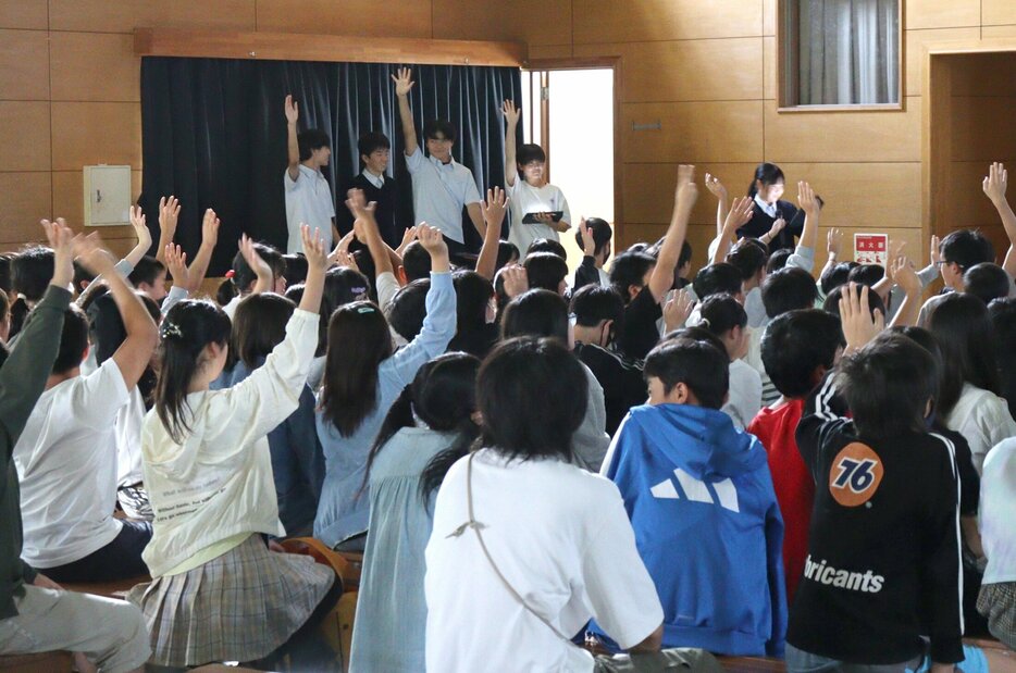 学校生活に関する３択クイズを楽しむ小学６年生（写真手前）と生徒会のメンバーら（同奥）＝京都府長岡京市・長岡第二中