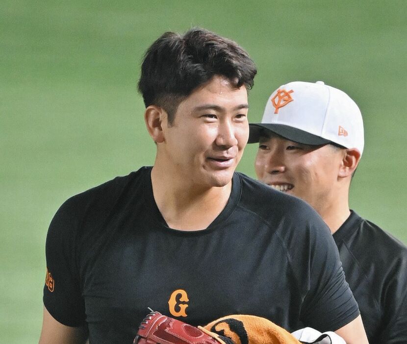 試合前練習を終えて引き揚げる巨人・菅野。奥は浅野