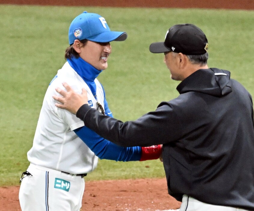 14日の試合後、握手を交わす日本ハム新庄監督(左)とロッテ吉井監督