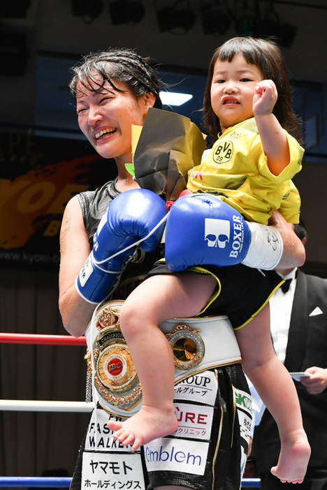 初代日本女子バンタム級王者となった吉田は愛娘を抱えあげた（写真・山口裕朗）