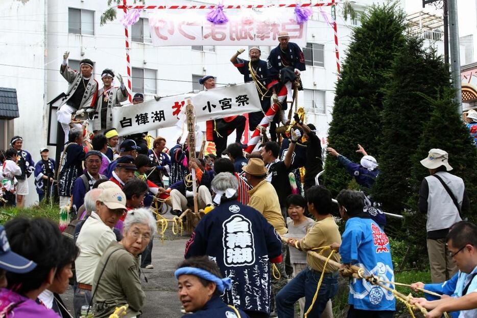 [写真]「木落し」直前の白樺湖・池ノ平神社の御柱。氏子だけでなく、観光客も参加した