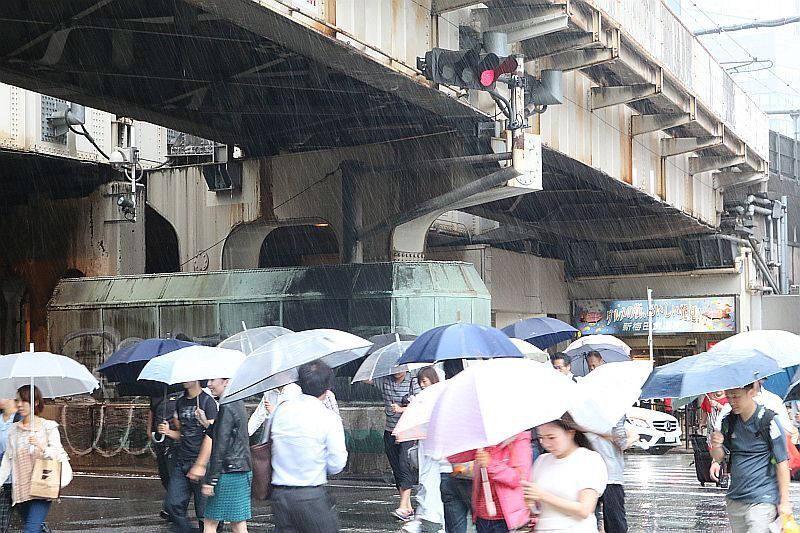 [写真]激しい雨風に移動するのも一苦労の状態に=20日午後12時半ごろ、大阪市北区で