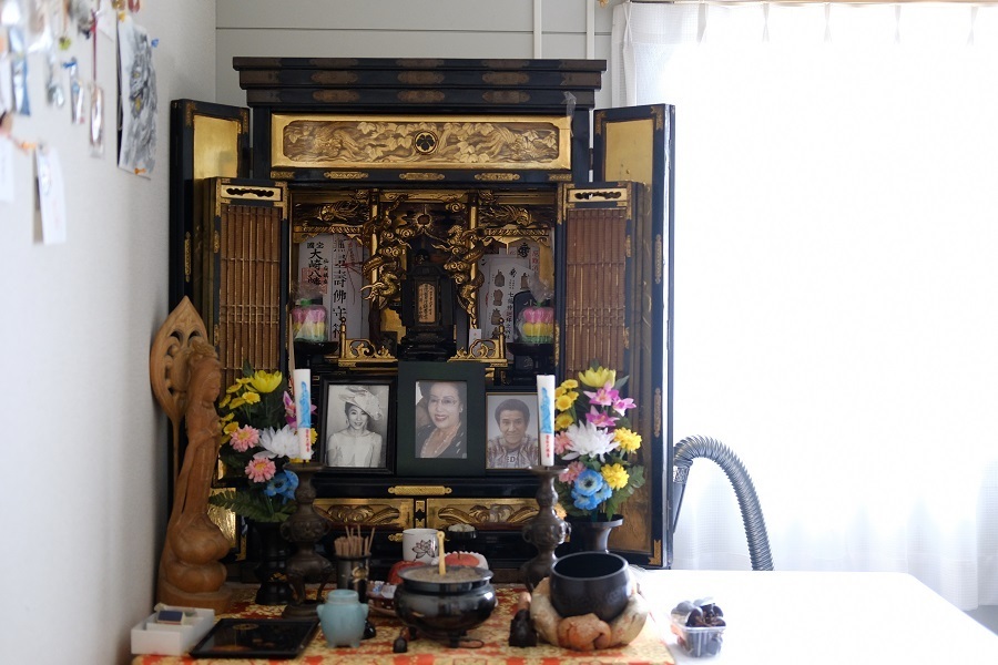 震災後、小川さんは息子も病気で亡くしている。寝室のベッド横に置かれた仏壇には、妻と息子の写真が並んでいた（撮影：山本宏樹/deltaphoto）