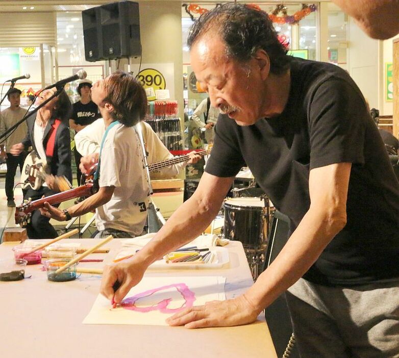 [写真]作品を描く黒田征太郎=28日夜、大阪市中央区で（撮影：柳曽文隆）