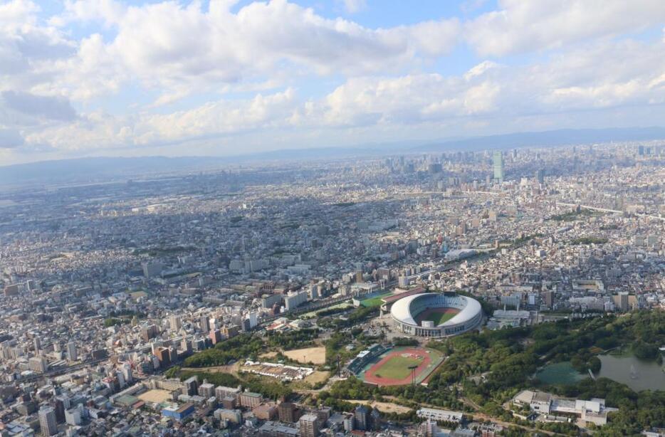 [写真]大阪市内は雲も広がっていた。長居公園やあべのハルカスも映る=18日午後3時半ごろ、大阪市東住吉区上空で（撮影：柳曽文隆）協力：小川航空