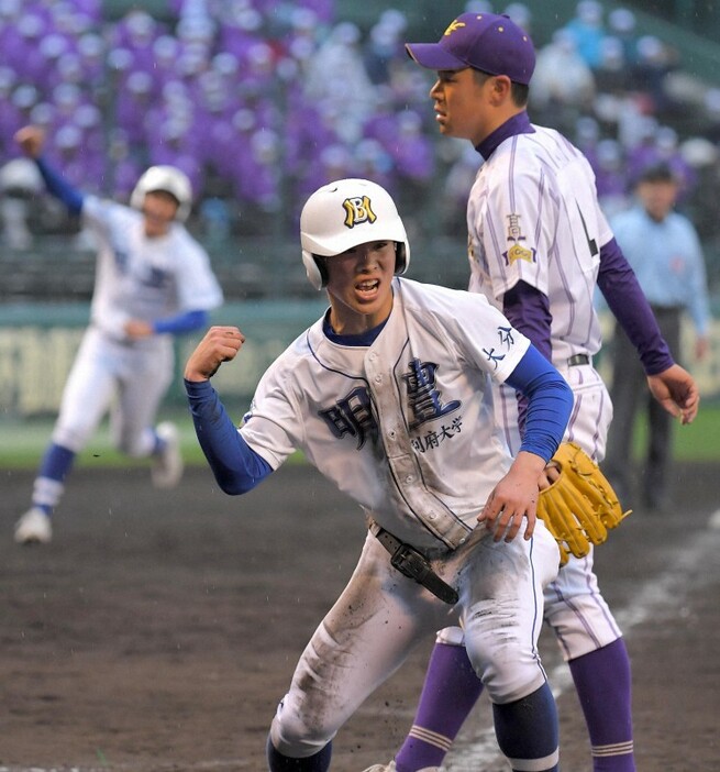 【東播磨－明豊】延長十一回裏明豊無死満塁、代打田中の時、東播磨の鈴木(右奥)が暴投。サヨナラのホームインを果たし喜ぶ、明豊三塁走者の黒木（手前）。左奥は一塁走者の山本＝阪神甲子園球場で2021年3月22日、津村豊和撮影