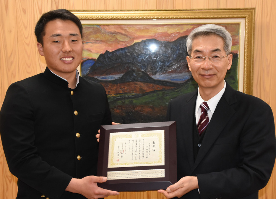 鳥取県高野連の山本英樹会長から表彰盾を手渡された鳥取城北高の吉田貫汰・前主将＝鳥取市の鳥取西高で、野原寛史撮影