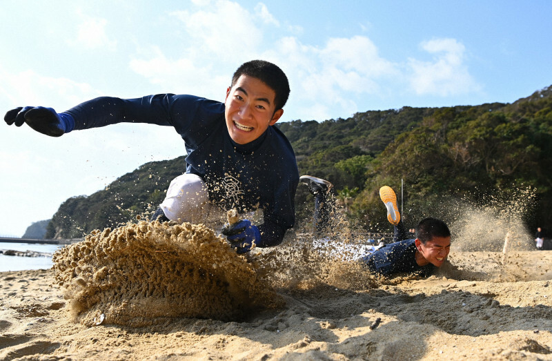 練習場近くの海岸で、砂浜に立てた棒を奪い合う大崎の選手たち＝長崎県西海市で、徳野仁子撮影