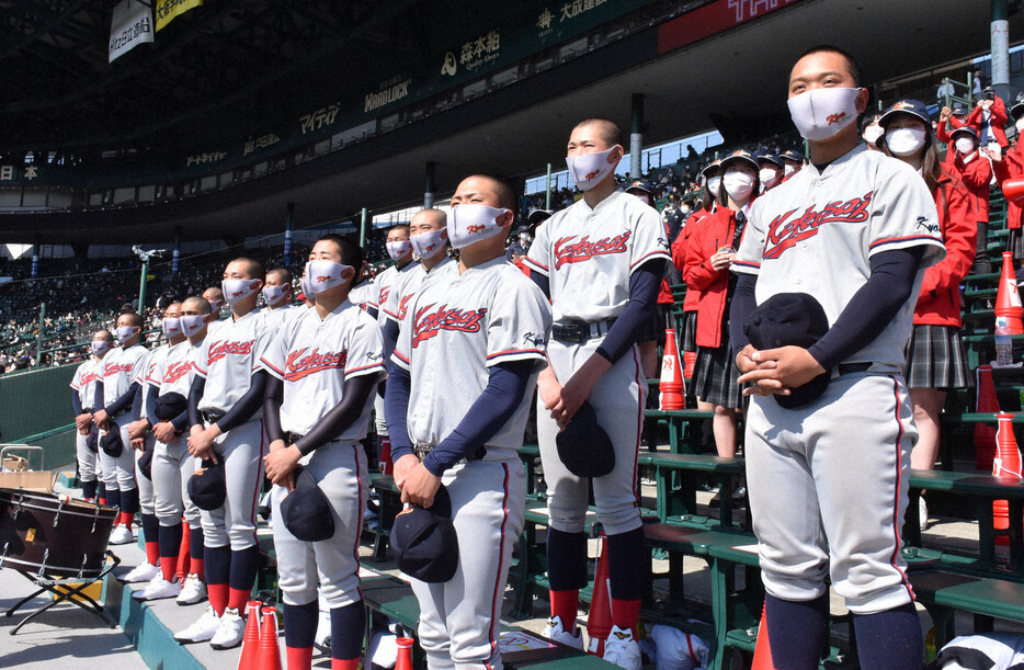 延長十回を制し、甲子園に流れる校歌をマスクをして静かに聴く京都国際の野球部員ら＝兵庫県西宮市の阪神甲子園球場で2021年3月24日午後2時10分、中島怜子撮影