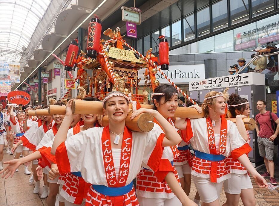 ［写真］「わっしょい」の掛け声とともに元気に練り歩くギャルみこし＝23日正午すぎ、大阪市北区で