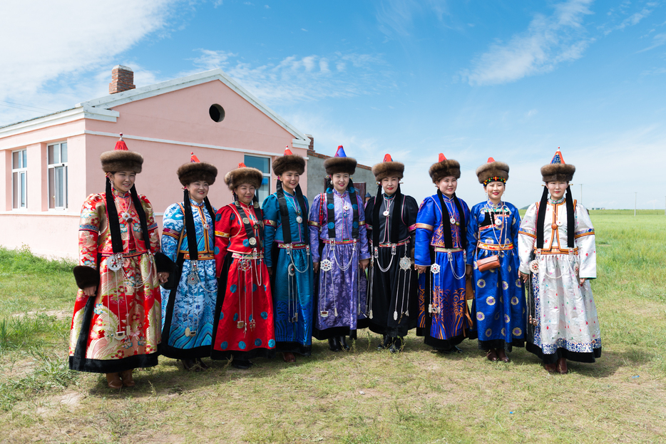 ブリヤート族の伝統衣装を身にまとい、新婦を送り出す友人達。右から2番目に立つ青い衣装の女性が新婦である。他の女性は全員既婚で髪を二つに分けているのが特徴だ＝フルンボイル市・エベンキ族自治旗（2018年8月撮影）