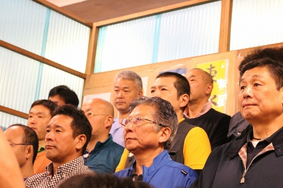 [写真]競りに先立ちあいさつした横田会長（前列右から3人目）と早山理事長（同2人目）