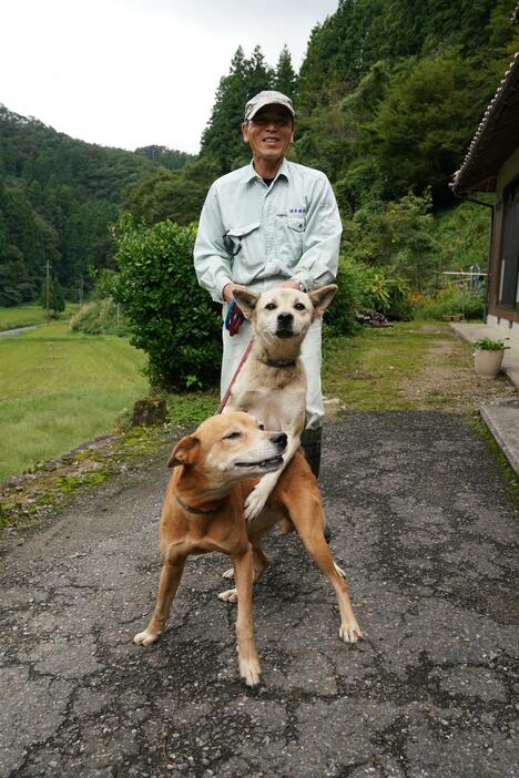 [写真]二川地区の自治会長、潮隆人さんと現役の猟犬たち
