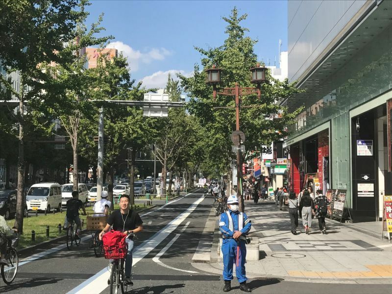 ［写真］社会実験で側道（左側）が閉鎖され、渋滞する車道を横目に自転車が通行していた。右は歩道＝9日午後1時半ごろ、大阪市中央区で（撮影：柳曽文隆）