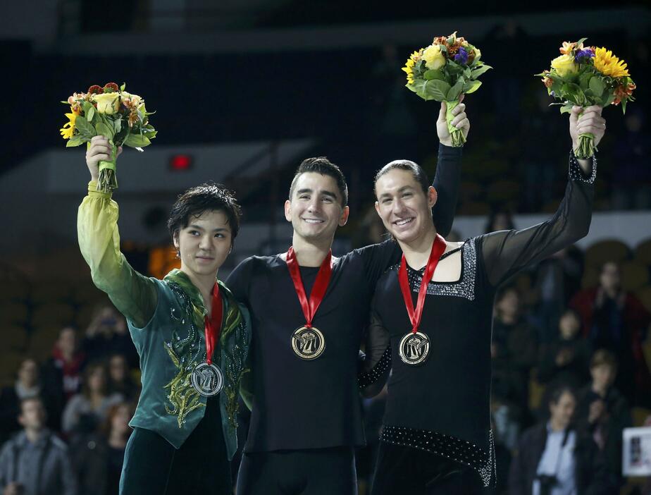 表彰台で花束をかざす。中央は優勝したマックス・アーロン、右が3位のジェイソン・ブラウン（ともに米国）＝2015年10月24日（写真：ロイター/アフロ）