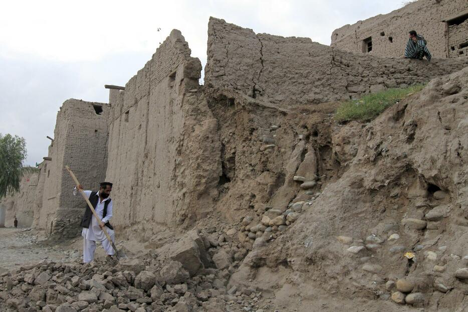 崩壊した家を片付ける男性。アフガニスタン北部の山岳地帯でM7.5の地震が発生＝2015年10月26日（写真：ロイター/アフロ）