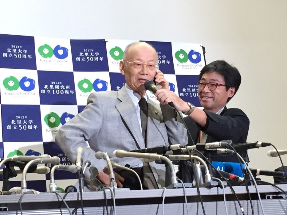 電話を手に取る大村智氏＝2015年10月5日