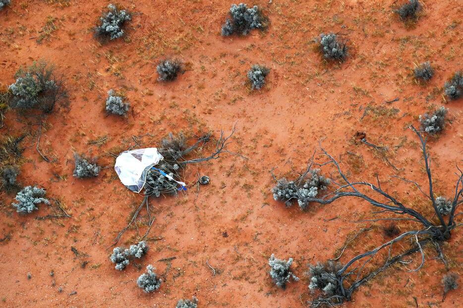 回収班のヘリコプターから撮影したパラシュートとカプセル（写真：JAXA）