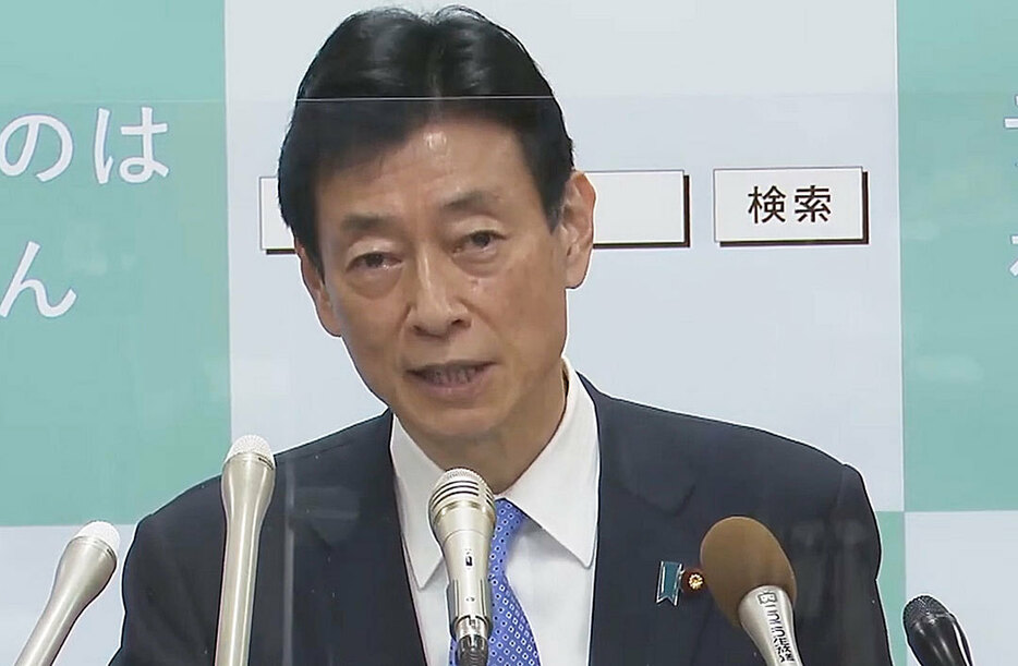 記者会見する西村担当相