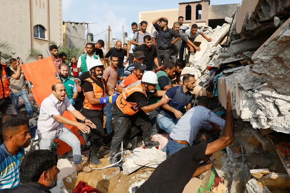 イスラエル軍の空爆で倒壊した建物の下を捜索する人々＝8日、パレスチナ自治区ガザ（ロイター＝共同）