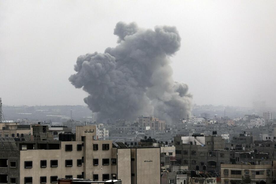 29日、ガザ市でイスラエル軍による空爆後、立ち上る煙（AP＝共同）