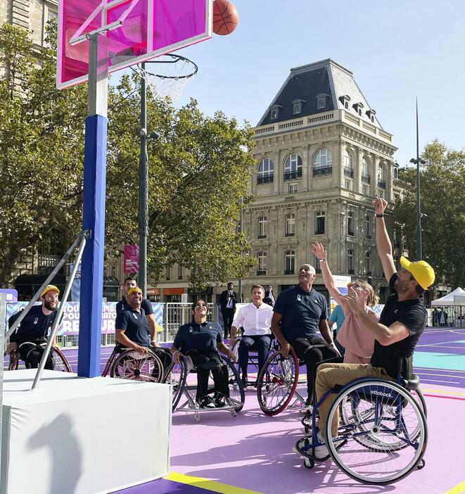 「パラリンピック祭」で車いすバスケットボールを体験するフランスのマクロン大統領（奥中央）＝8日、パリ
