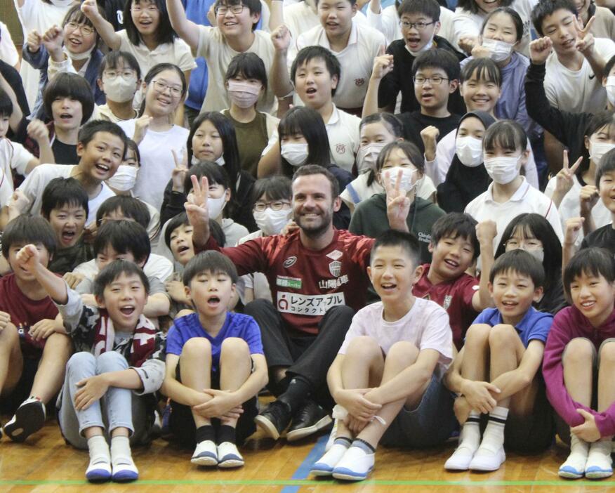 神戸市内の小学校を訪れ、児童らと記念写真に納まるJ1神戸のマタ（中央下）＝12日
