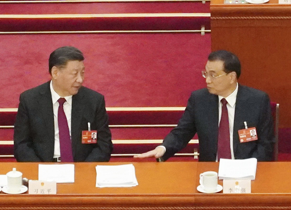 3月5日、中国全人代で言葉を交わす習近平国家主席（左）と李克強首相（当時）＝北京の人民大会堂（共同）