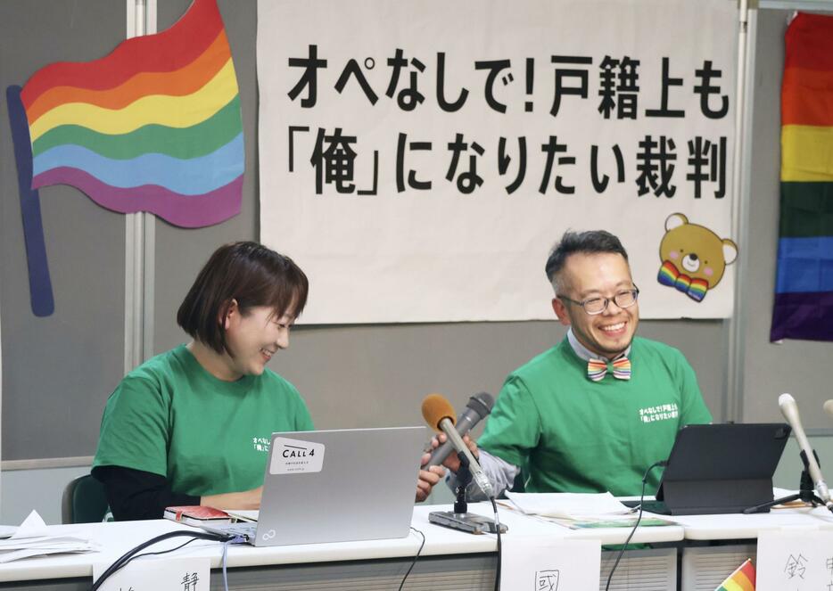 性別変更が認められ、記者会見で笑顔を見せる鈴木げんさん。左はパートナーの国井良子さん＝13日午後、浜松市