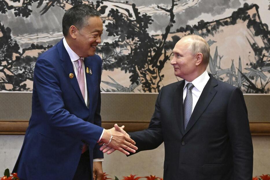会談に先立ち、プーチン大統領と握手を交わすタイのセター首相＝17日、北京（AP＝共同）