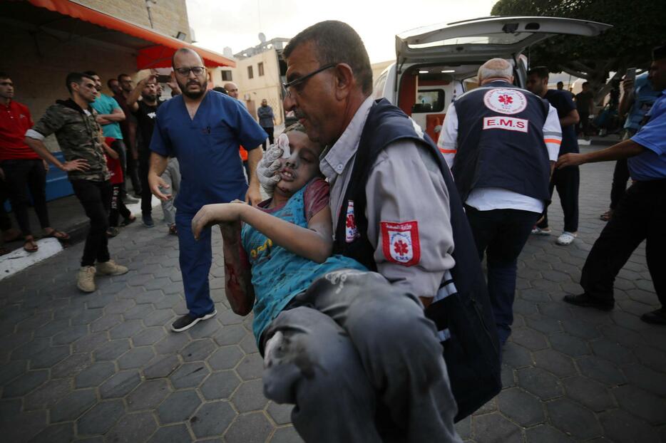 16日、パレスチナ自治区ガザの病院に運び込まれる子ども（ゲッティ＝共同）