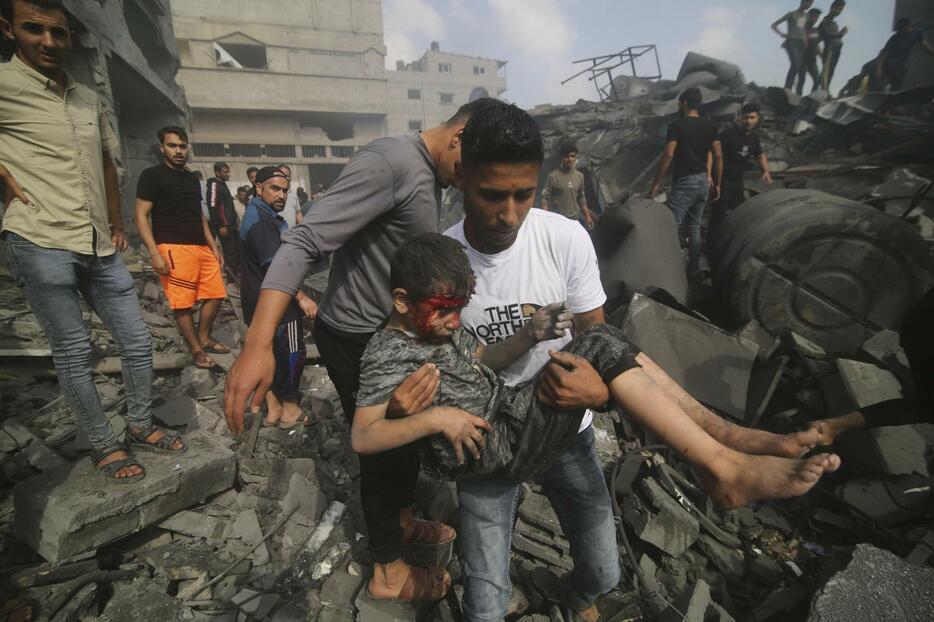 22日、イスラエル軍の攻撃を受けた建物から救出される子ども＝パレスチナ自治区ガザ南部ラファ（AP＝共同）
