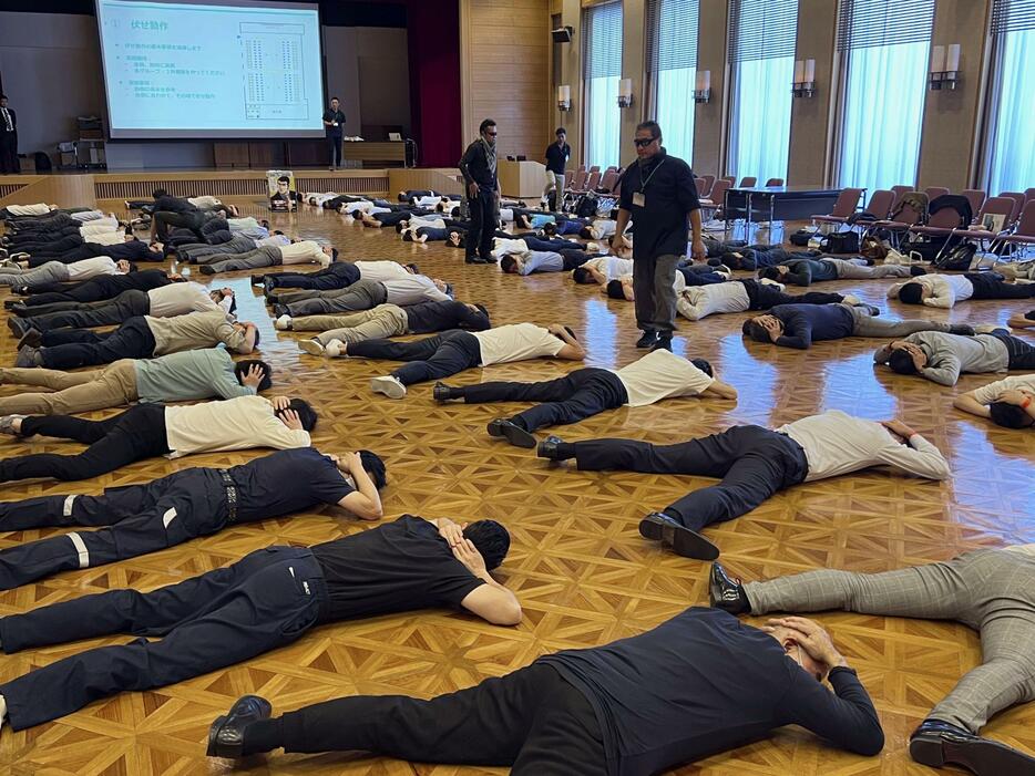 銃撃や爆発に遭遇した場合を想定した訓練で、安全姿勢を取る参加者ら＝17日午後、東京都港区