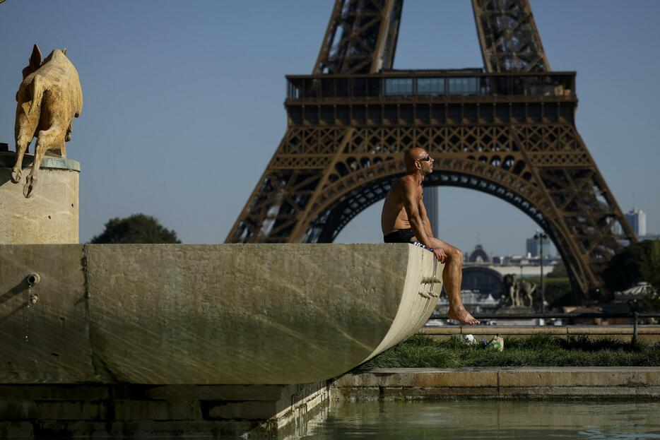パリのエッフェル塔前で日光浴をする男性＝9月7日（AP＝共同）