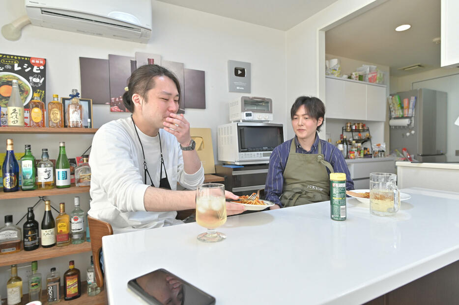 料理を試食するスタッフの小川さん（左）。リュウジさんとは千葉の飲み屋で知り合ったという