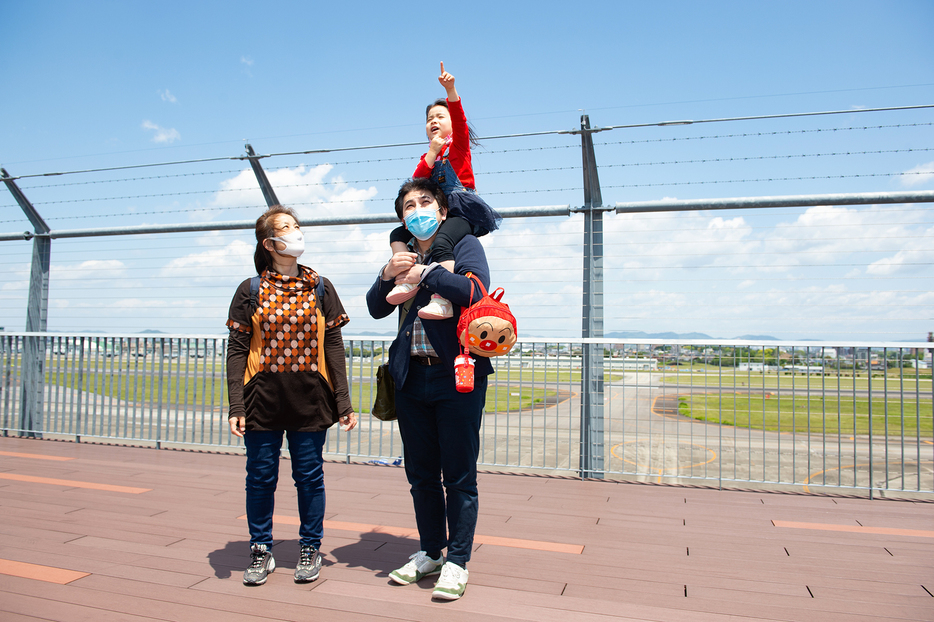 「あいち航空ミュージアム」の展望デッキから空を眺める愛知県内の親子（2021年5月3日、撮影：夏目健司／NAMEDIA）