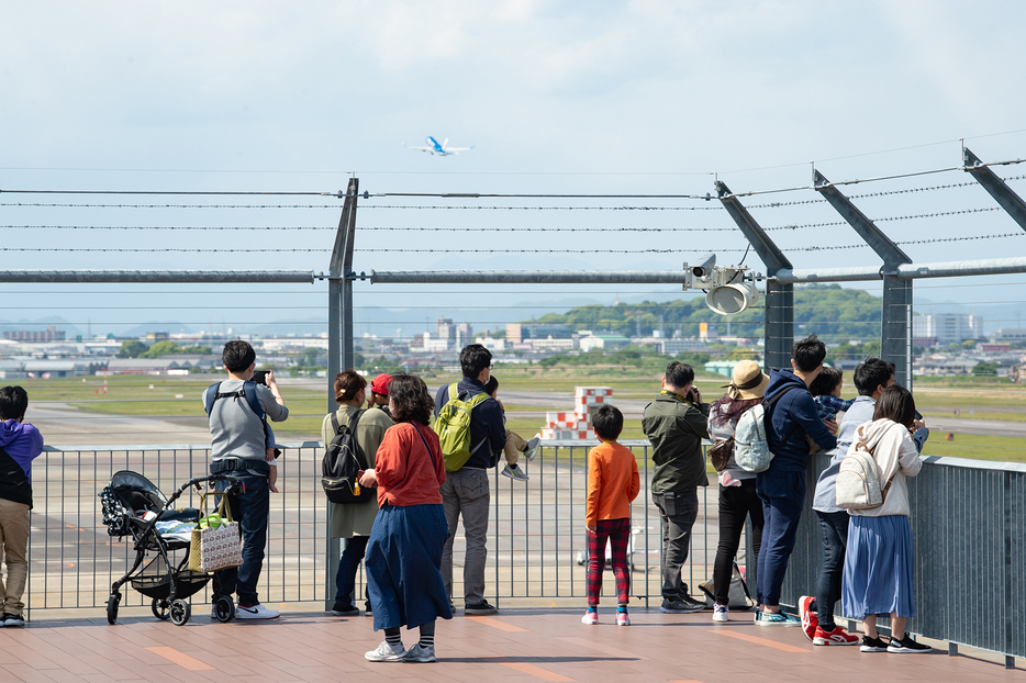 愛知県営名古屋空港の滑走路から飛び立つ飛行機を眺める親子連れら（2021年5月3日、撮影：夏目健司／NAMEDIA）