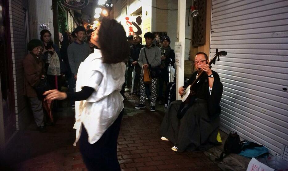 ドッキリヤミ市場で三味線を演奏する鈴木さん（右）　(c)紀あさ