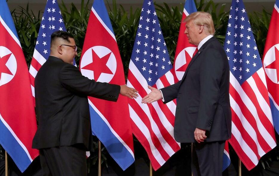 [写真]初めて対面し、握手をかわそうとするトランプ大統領（右）と金正恩委員朝 （ロイター/アフロ）