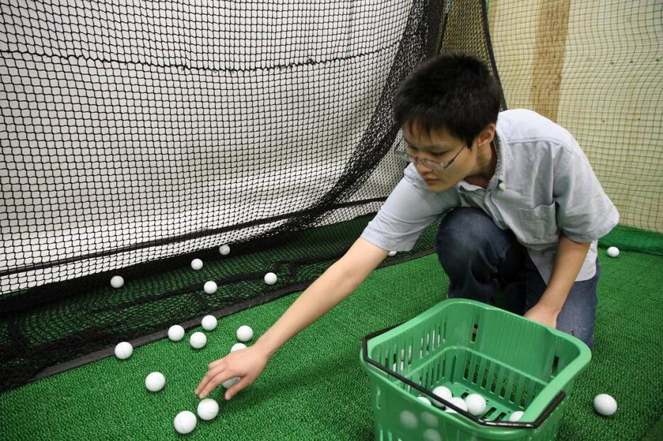 ゴルフ練習場でボールを拾う作業に臨む通所者の加藤さん（名古屋市守山区で）