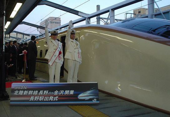 [写真]長野駅で金沢行き一番列車「はくたか591号」の発車合図をする加藤久雄長野市長（左）と大峽和志長野駅長