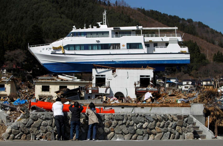 津波に押し流され民宿の屋根に乗った大槌町の観光船「はまゆり」＝2011年4月17日（ロイター/アフロ）