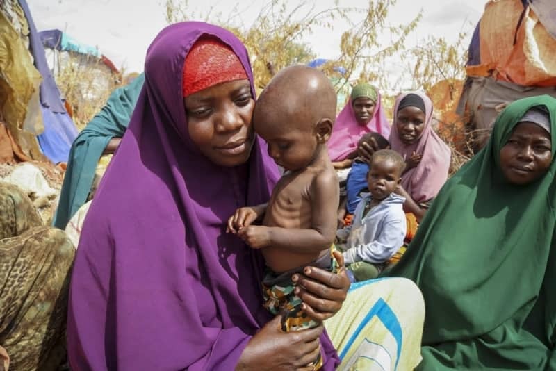 ソマリアの首都モガディシオ郊外で、栄養失調の子どもを抱く母親＝２０２２年６月（ＡＰ＝共同）