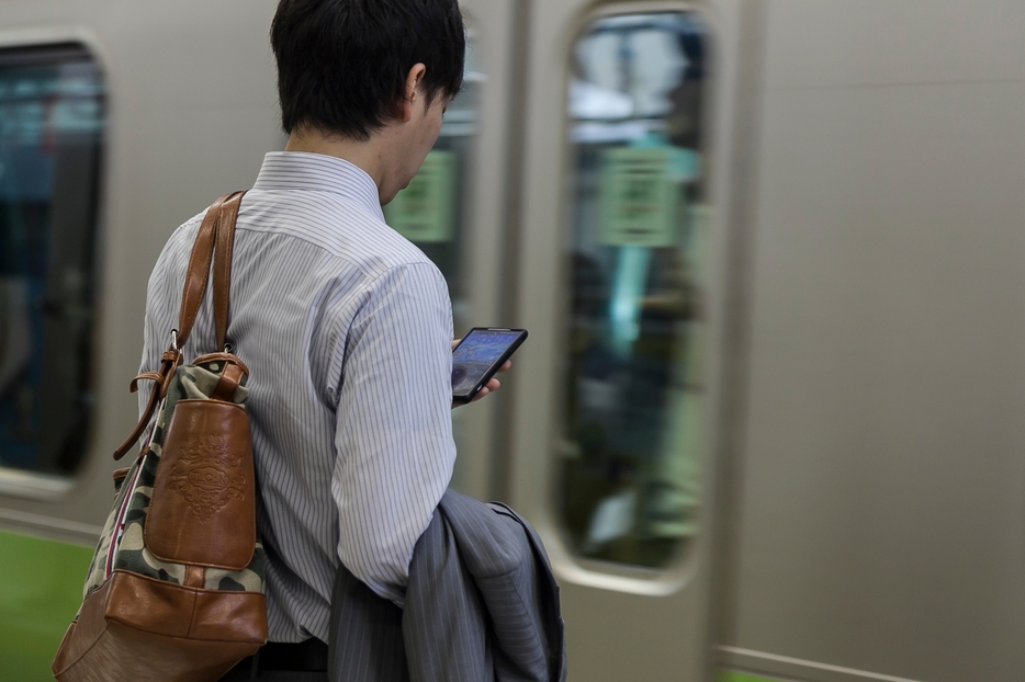 電車に乗るときも降りるときもスマホから目を離さない人も少なくない（写真：Rodrigo Reyes Marin/アフロ）