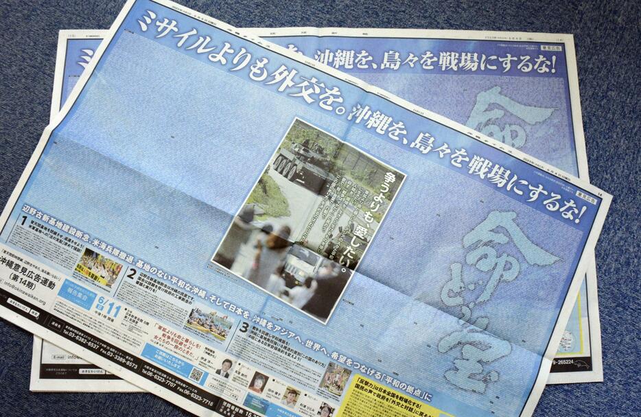 「ミサイルよりも外交を」など記された、市民グループの意見広告が掲載された沖縄タイムスと琉球新報の紙面