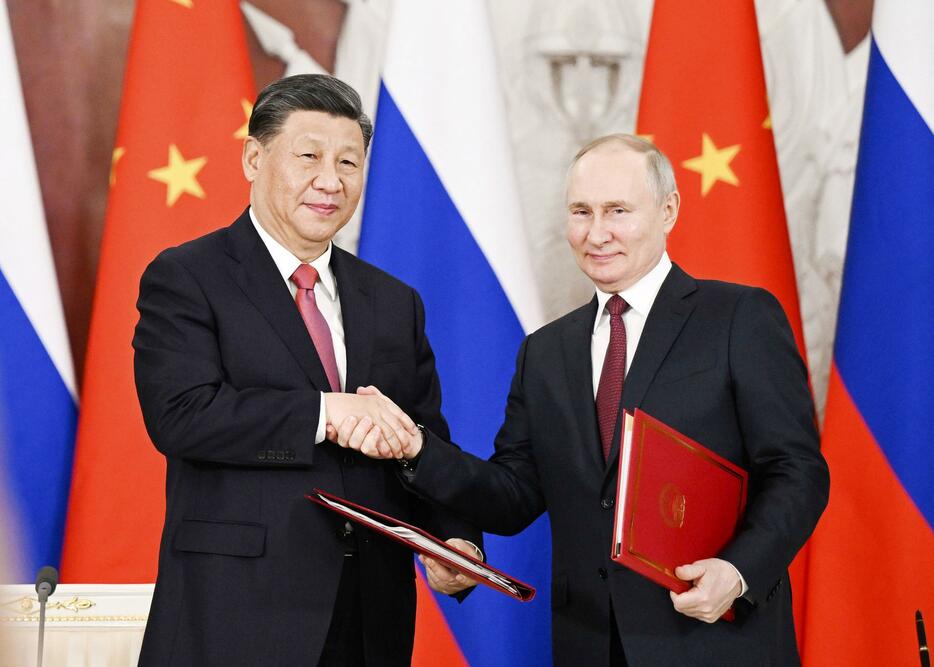 共同声明に署名し握手を交わすロシアのプーチン大統領（右）と中国の習近平国家主席＝3月、モスクワ（新華社＝共同）