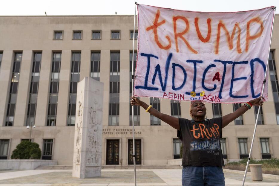 1日、米ワシントンの連邦裁判所前で「トランプ起訴される」の横断幕を掲げる人（AP＝共同）
