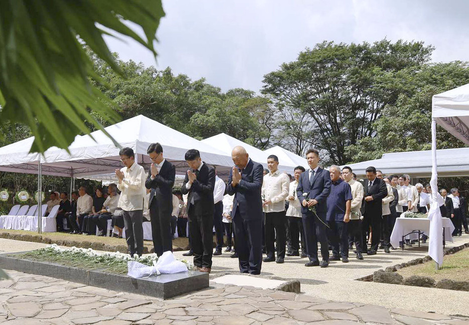 15日、フィリピン・ルソン島ラグナ州のカリラヤ日本人戦没者慰霊園で献花し手を合わせる慰霊祭の参加者（共同）